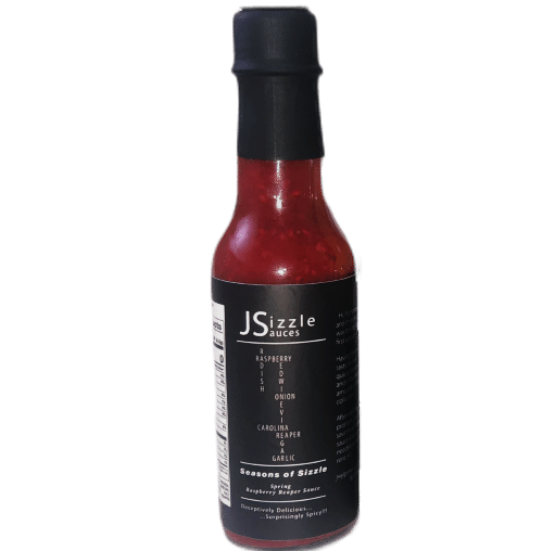 A bottle of J Sizzle's Raspberry Reaper Hot Sauce. Sophisticated packaging containing a vibrant burgundy colored hot sauce made from the freshest seasonal ingredients. Clicking the bottle will take you to the dedicated Raspberry Reaper page where you can add it to your cart.